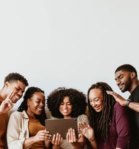 Friends gathered around a tablet, smiling