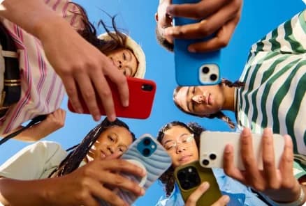 Young people holding up their phones, seen from below